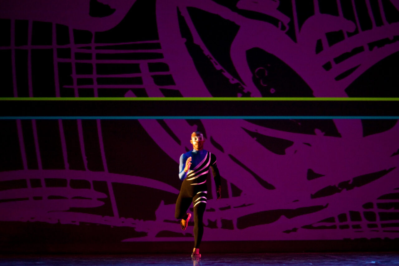 Solo dancer in running stance facing the audience