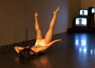 A dancers does a flip with her legs behind her