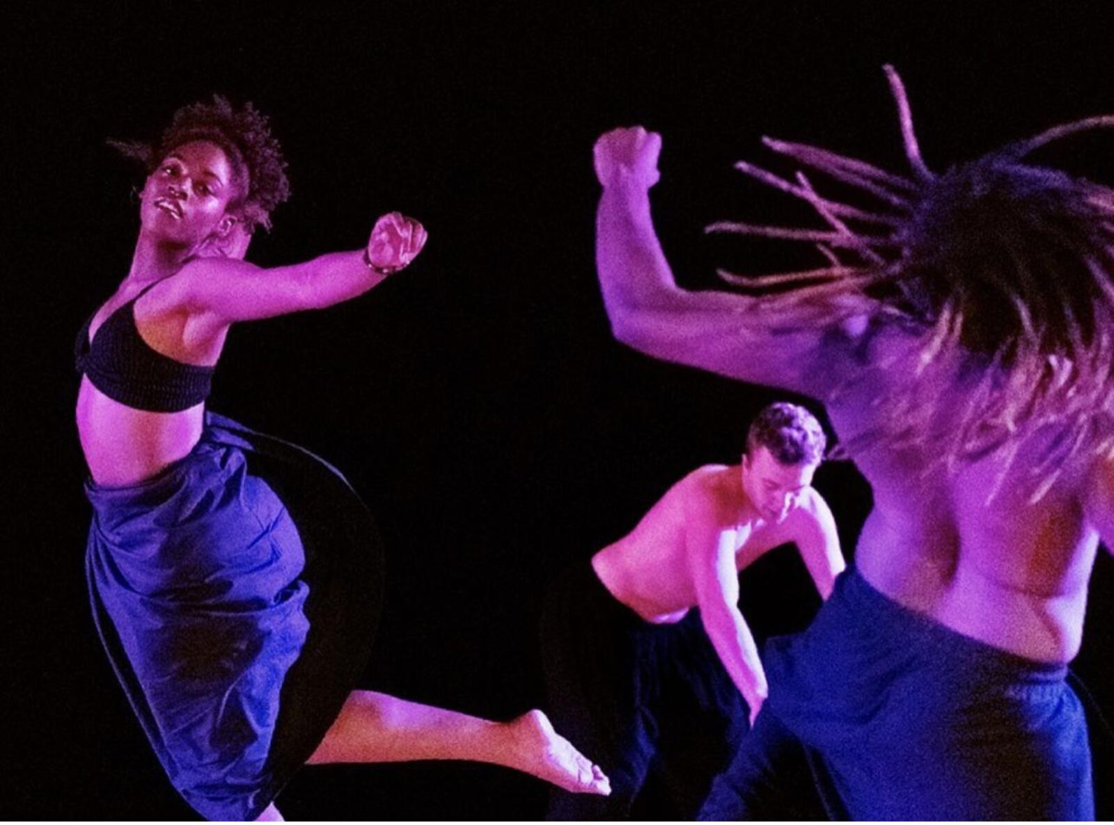 A trio of dancers move through the air