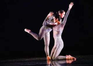 two people in leotards dance together onstage