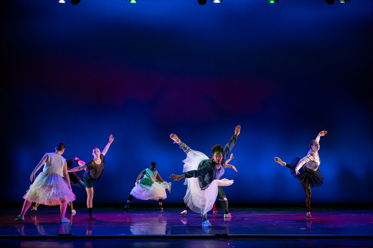 Dancers on stage with purple background