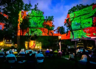 Projection on the Erlanger House with people watching outside