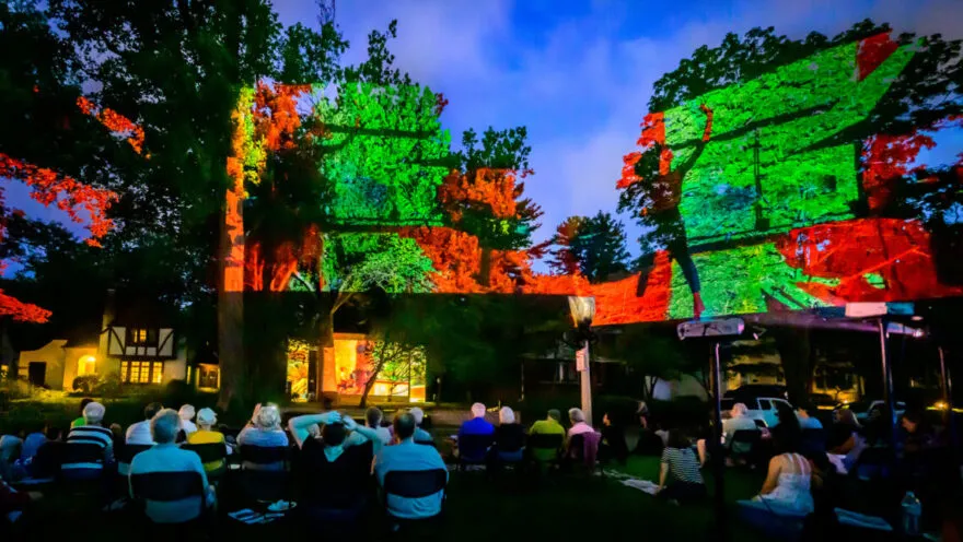 Projection on the Erlanger House with people watching outside