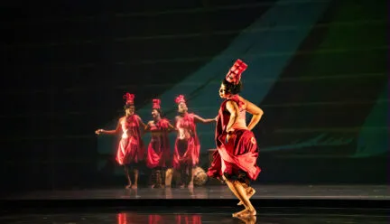 4 dancers on stage dressed in red 