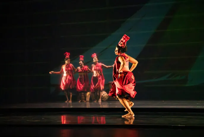 4 dancers on stage dressed in red 