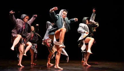 dancers onstage with legs up