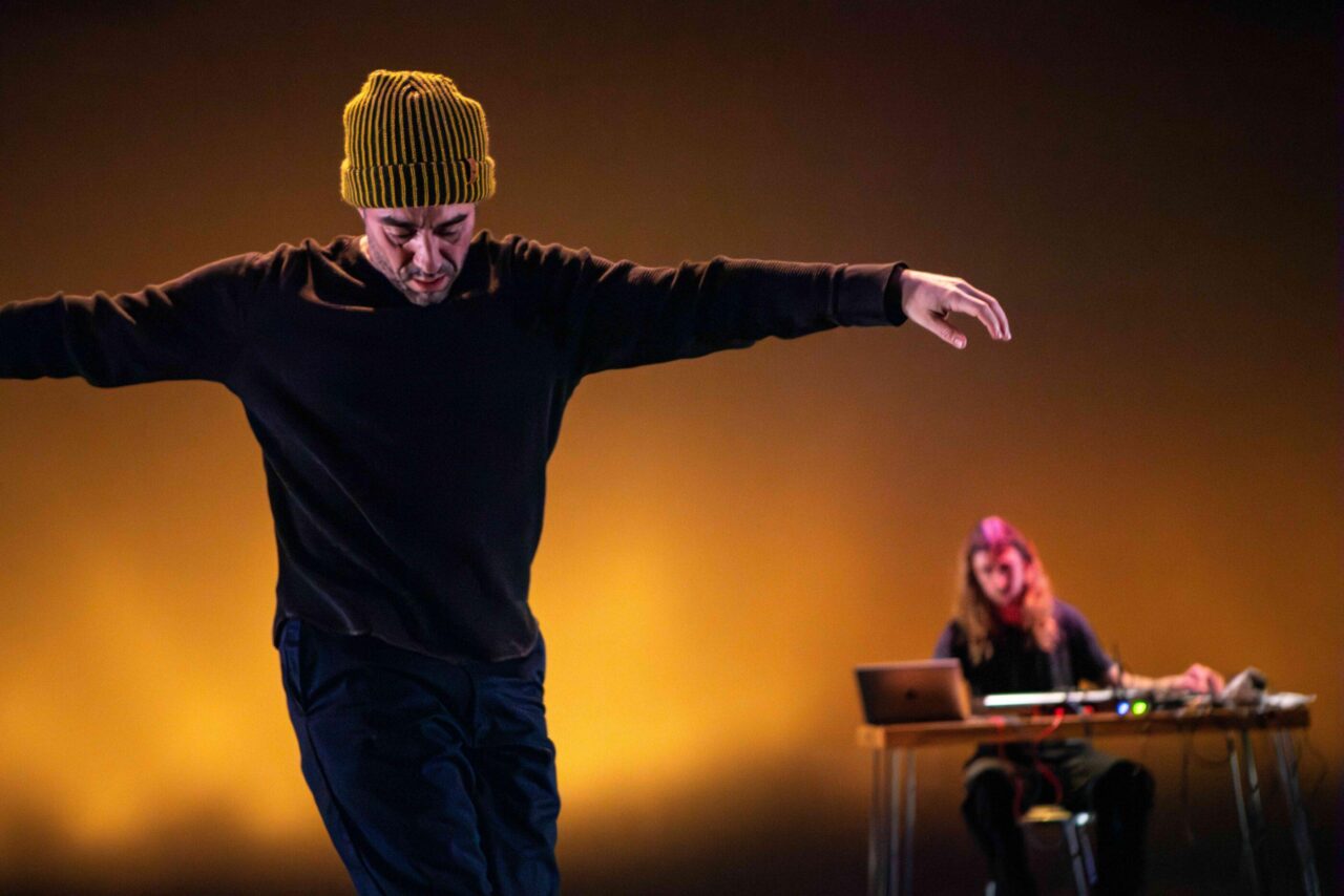 dancer opening arms and looking down