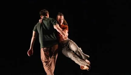 One dancers picks up another on his hip