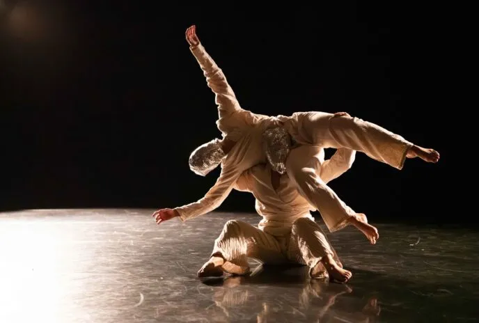 one masked dancers being lifted by another