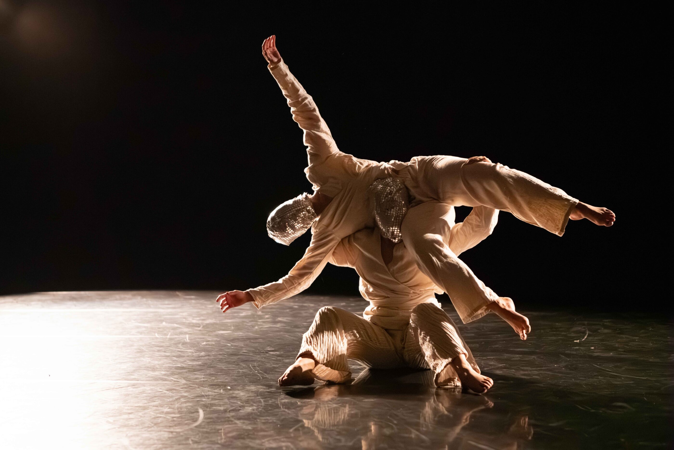 one masked dancers being lifted by another