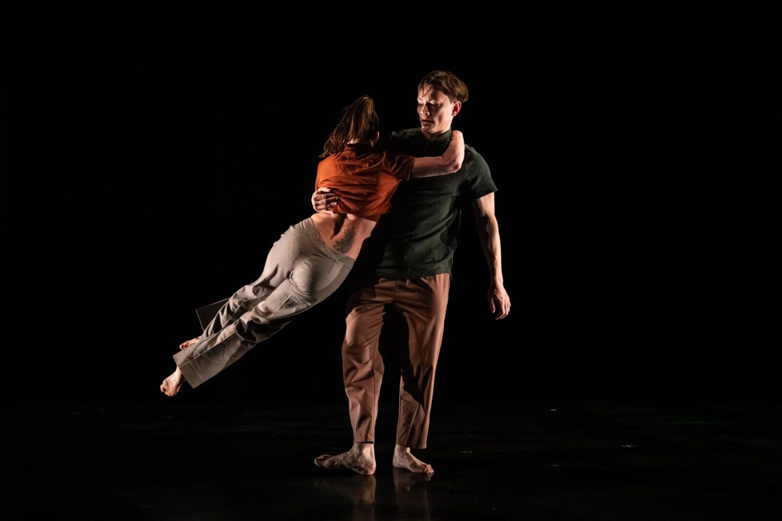 a dancer jumps over another dancer