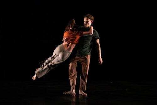 a dancer jumps over another dancer