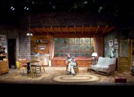 Person sitting in chair center stage during a production