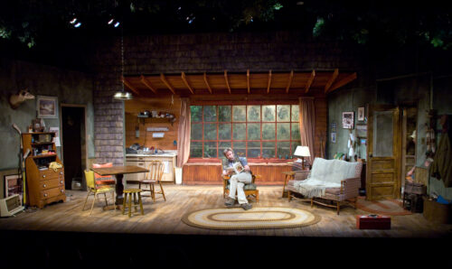 Person sitting in chair center stage during a production