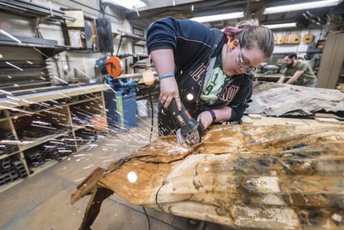 Student using power tool to cut object