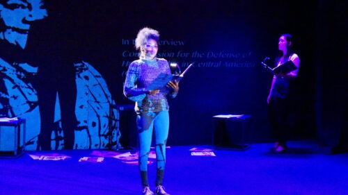 Actors in costume reading from script on stage