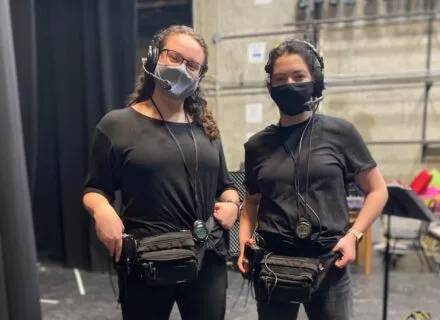 Two students calling show from back stage