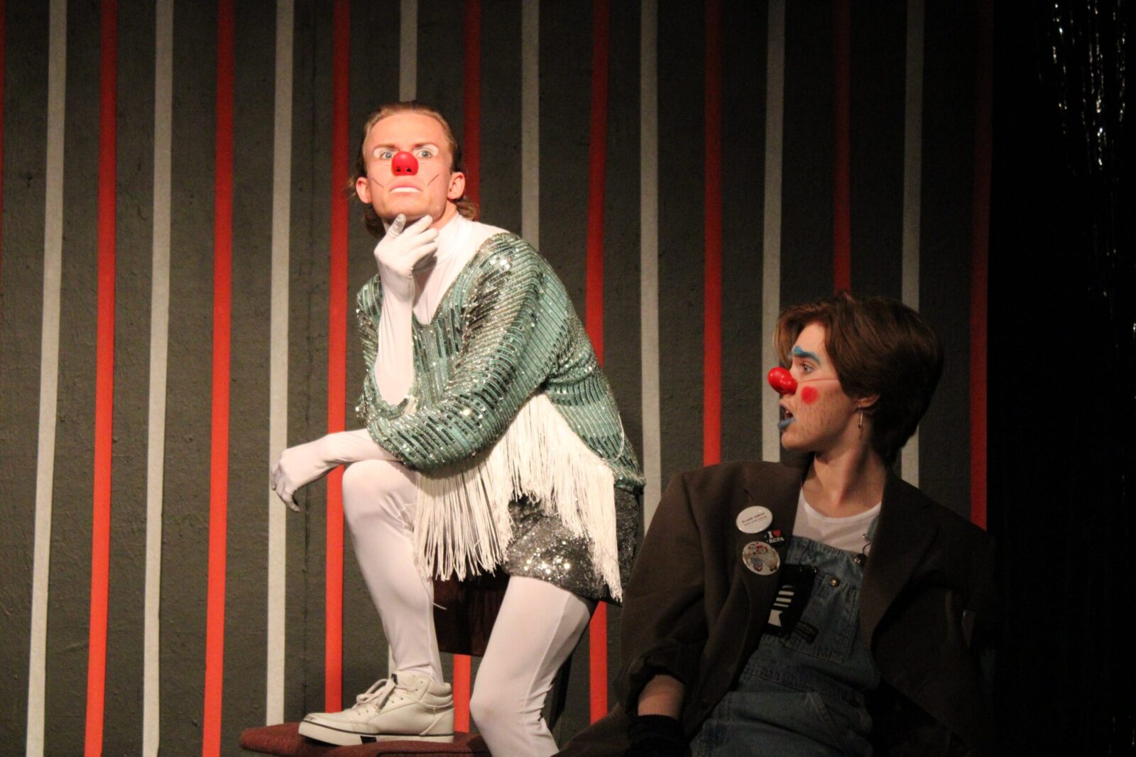 2 actors on stage striking a pose with clowning makeup on