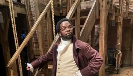 johnathan stands on hamilton stage dressed in costume