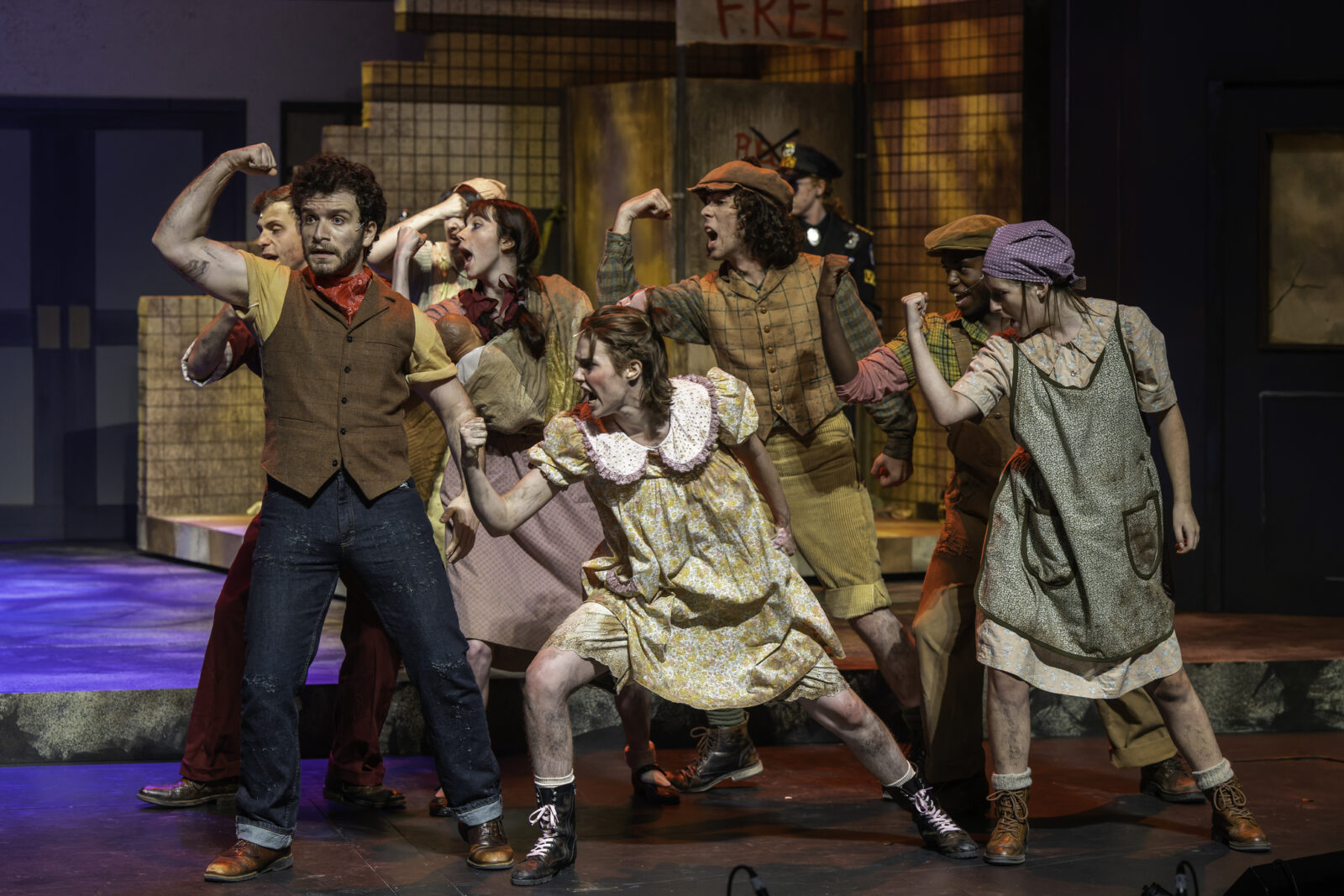 many actors on stage in a dancing pose