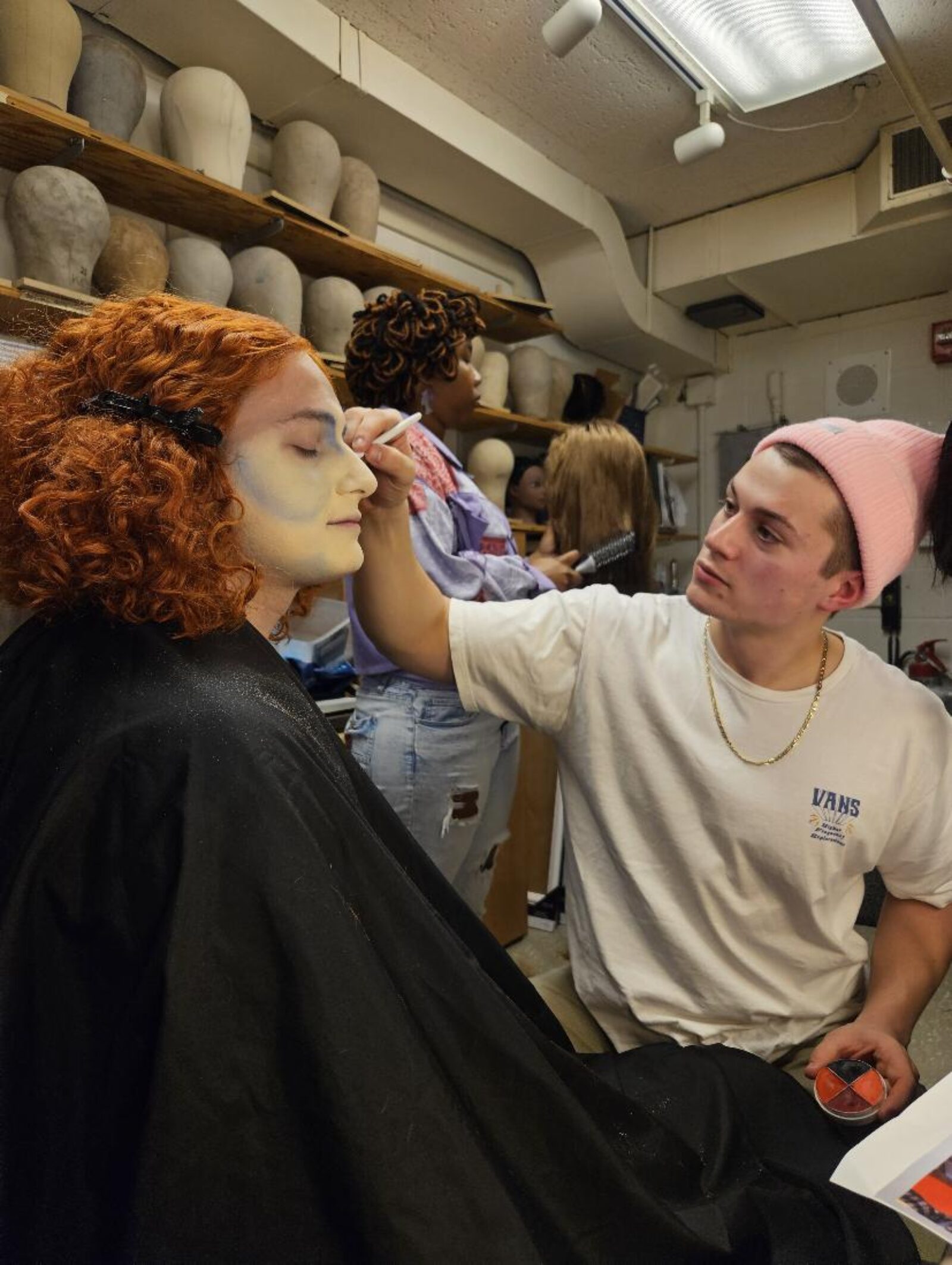 person applying costume makeup to another person