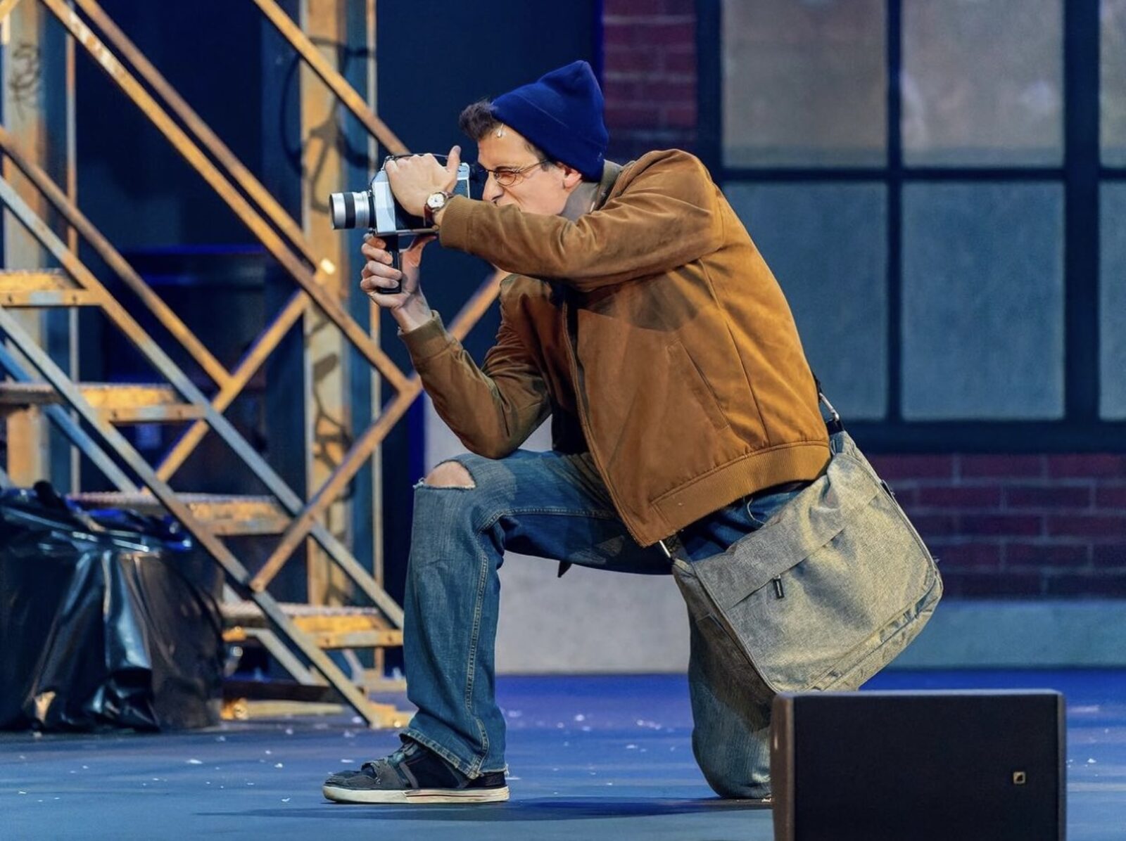man performing on stage with camera