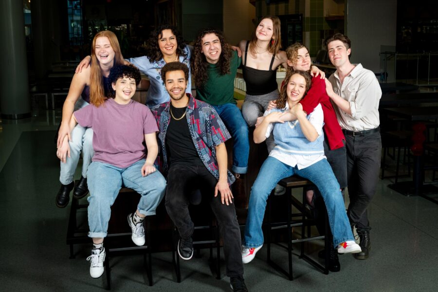 many people gathered on and around a table smiling