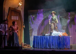 people on stage, one stands on a table