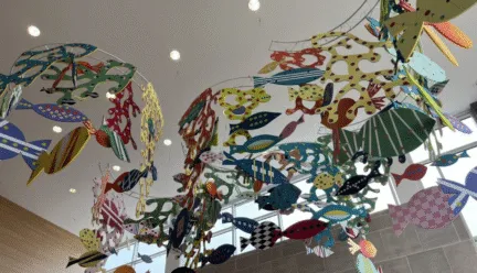 art installation hanging from ceiling with fish and coral