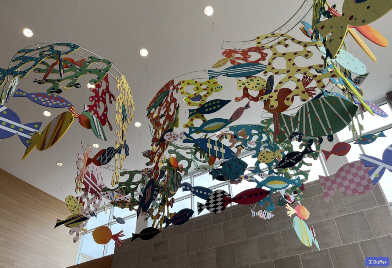 art installation hanging from ceiling with fish and coral
