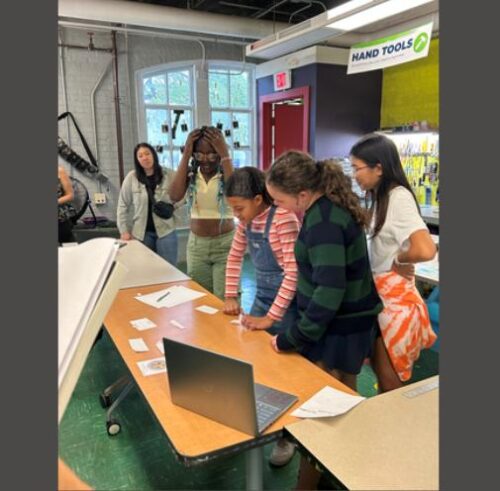 several students together looking at table with game items