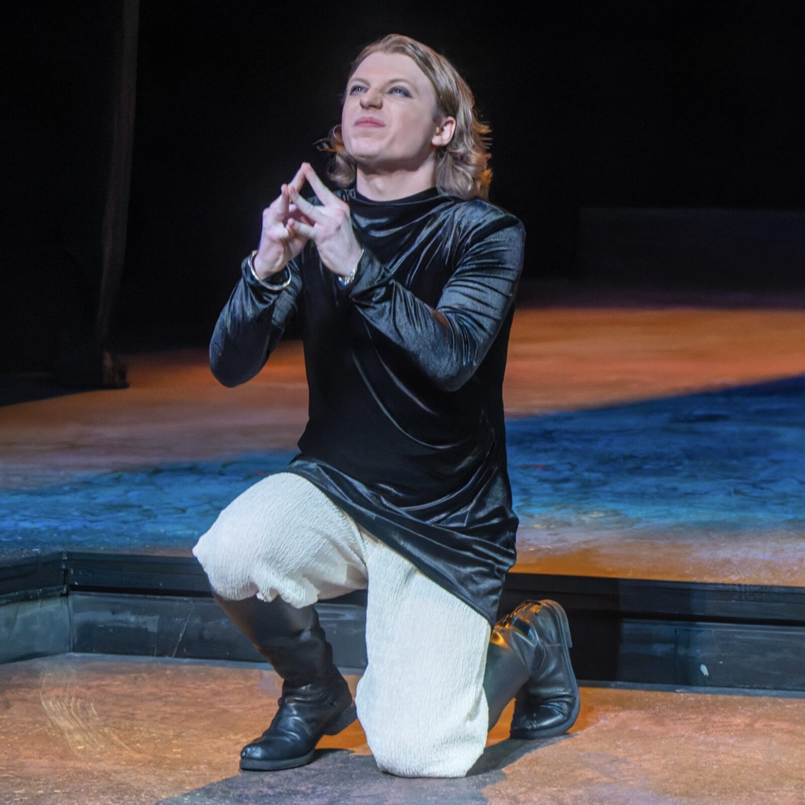 a person kneeling with hands in prayer-like position