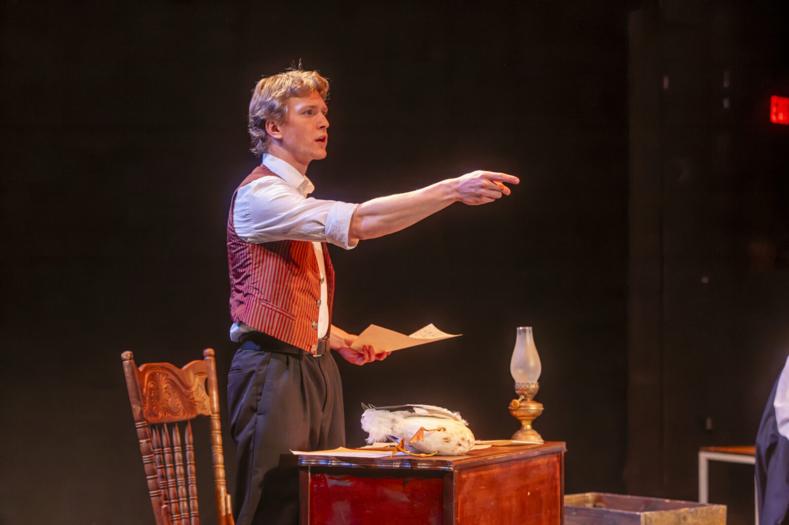 a person onstage holding out their arm and pointin