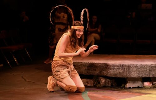 a person onstage wearing antennae and kneeling