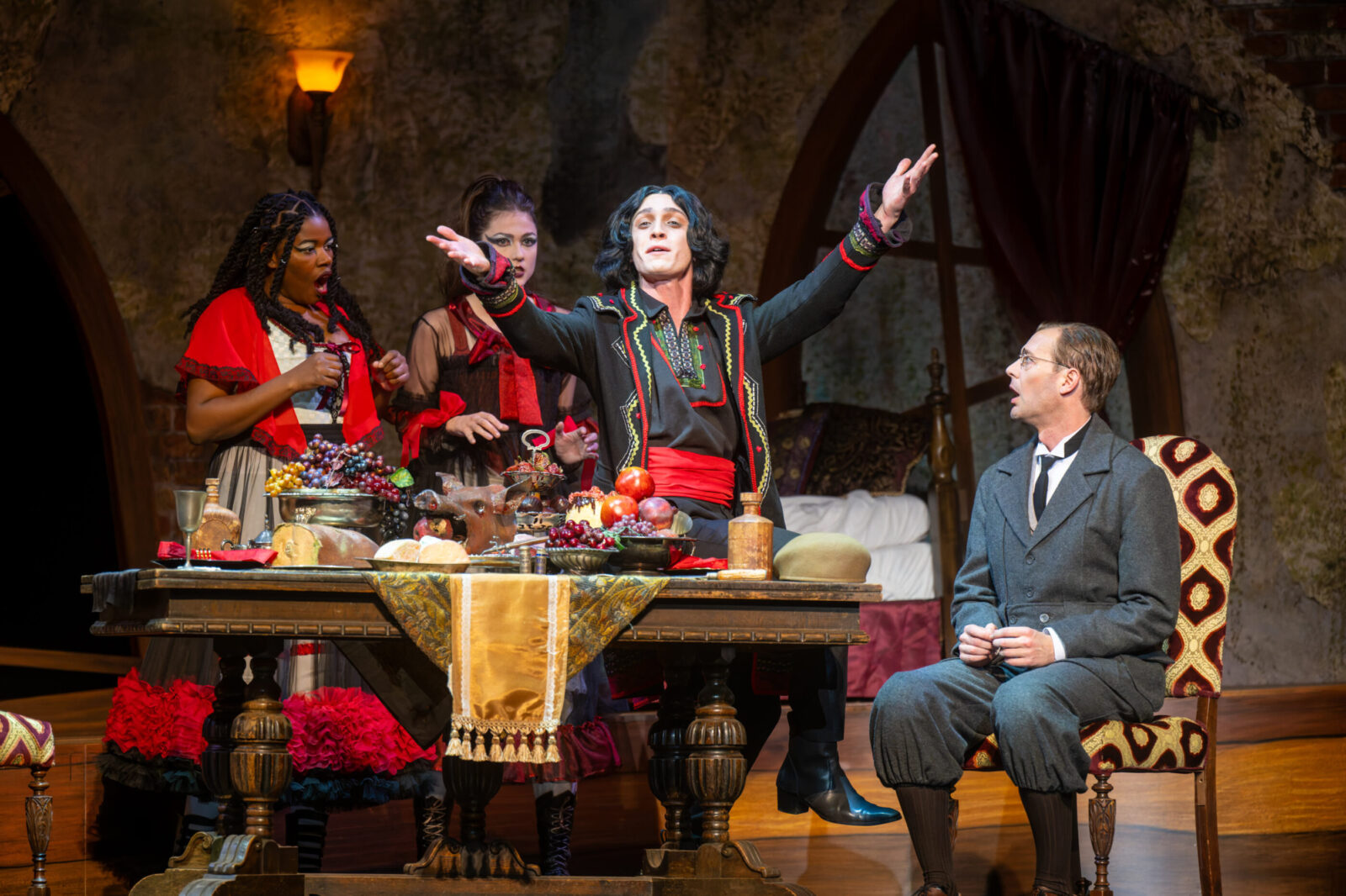 several people onstage around a dinner table