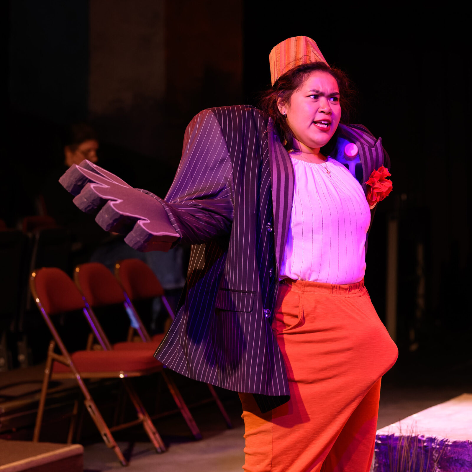 person onstage with arms outstretched