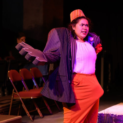 person onstage with arms outstretched