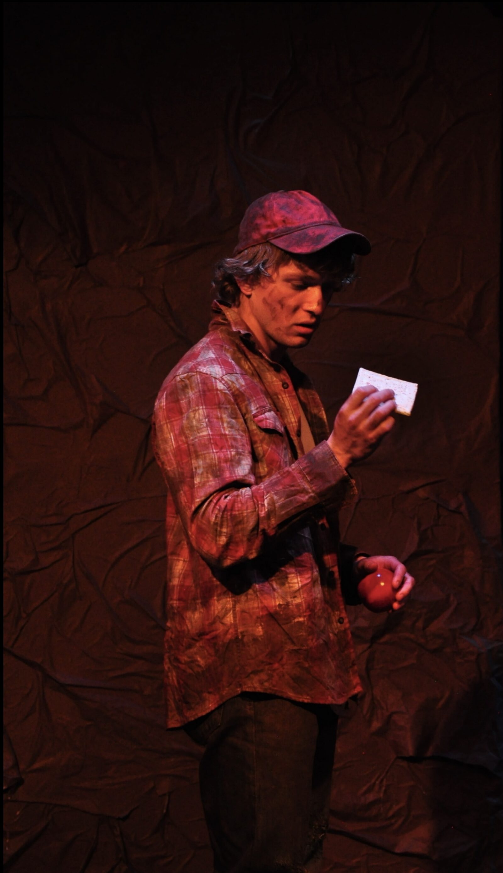 a person onstage holding and reading a letter