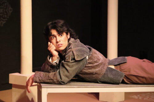 a person lies on a bench with a look of surprise