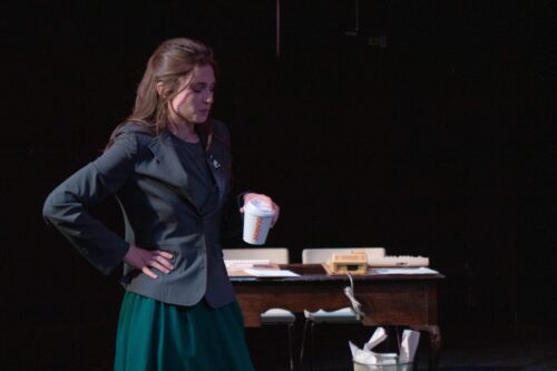 a person onstage with hands on hips