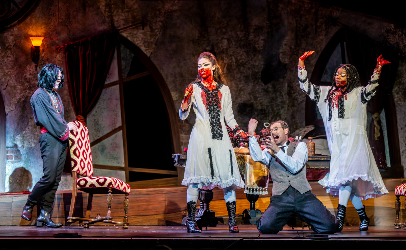 several people onstage with fake blood all over them