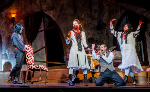 several people onstage with fake blood all over them