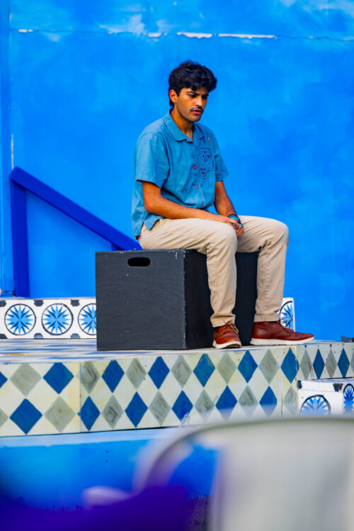 person sitting on stool onstage