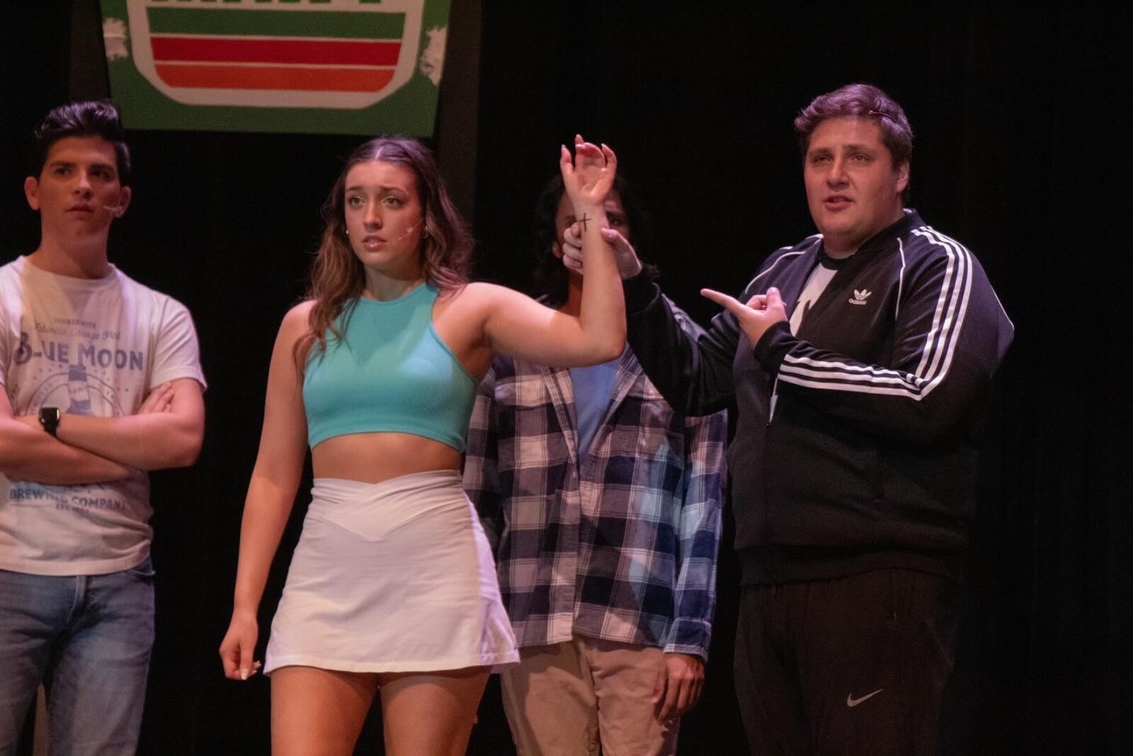 several people onstage, one person holds another person's arm up