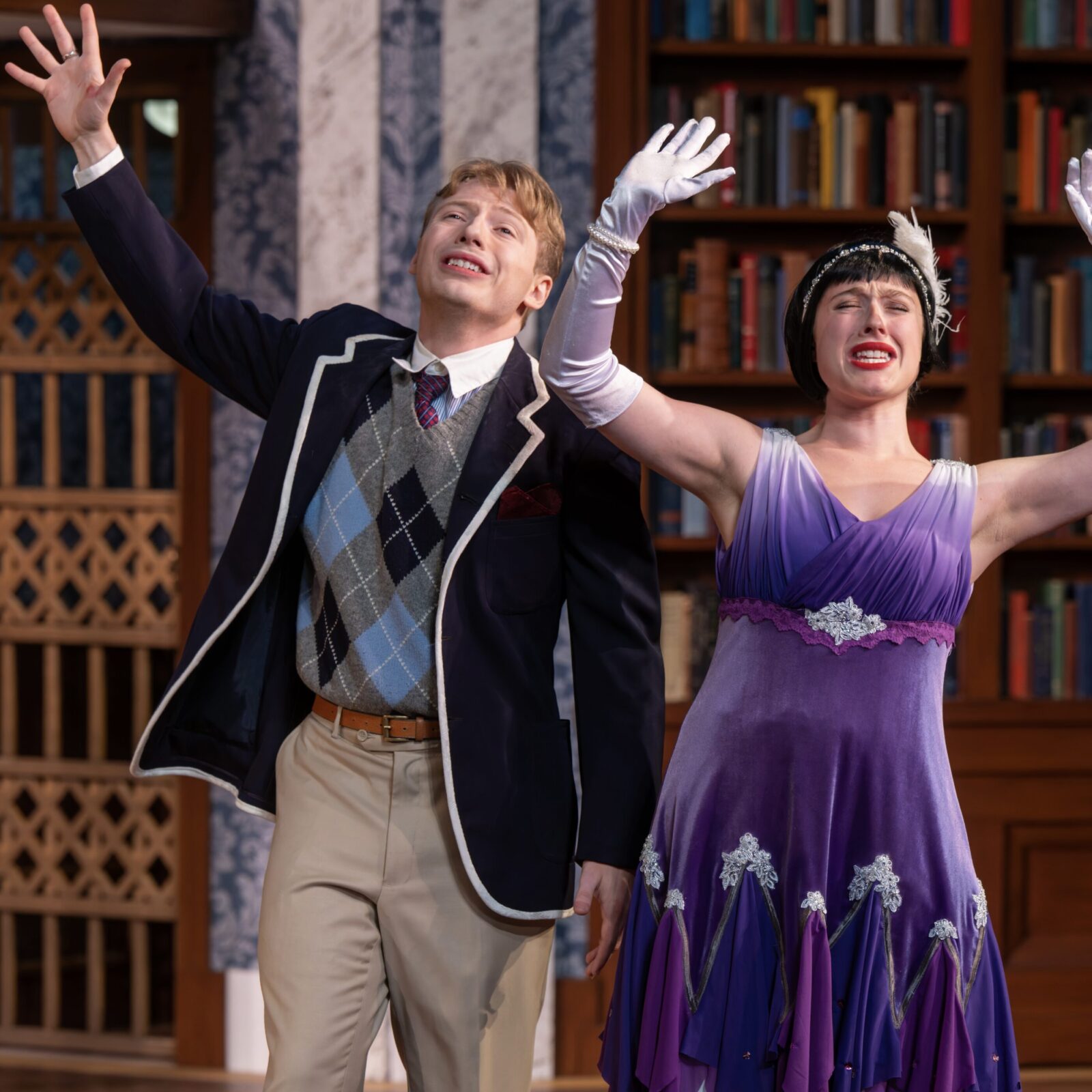 two people with arms outstretched onstage