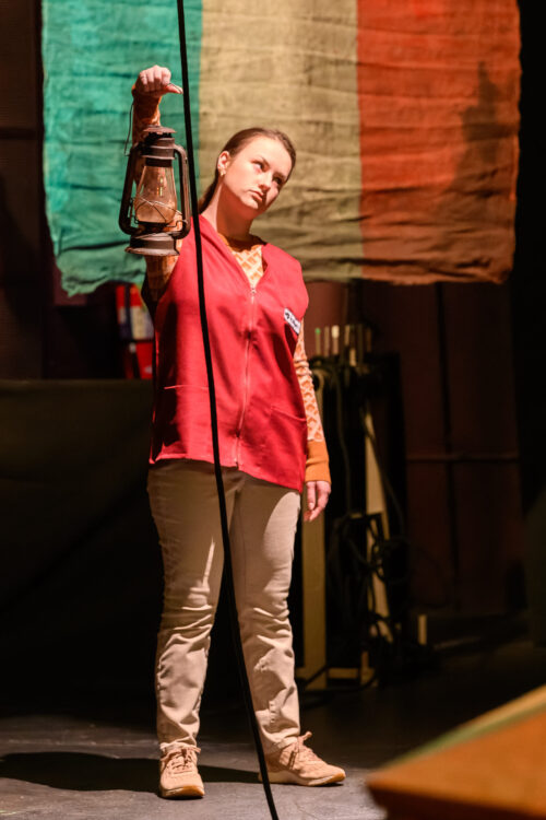 a person onstage holding a lantern