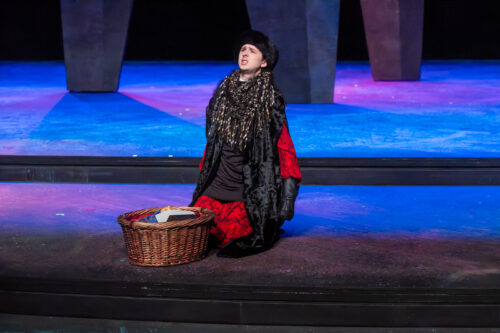 person kneeling with basket in front of them onstage