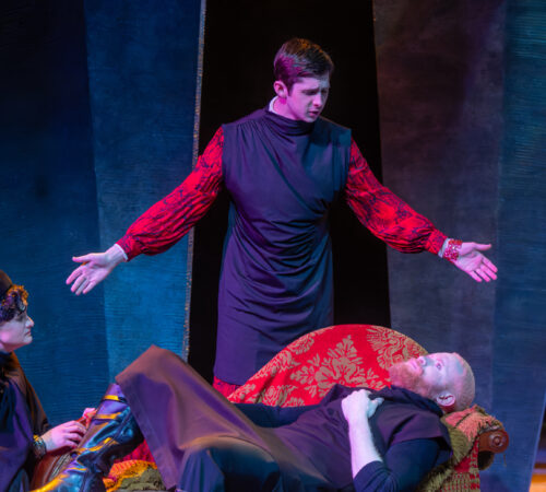 several people onstage, one with arms outstretched to sides