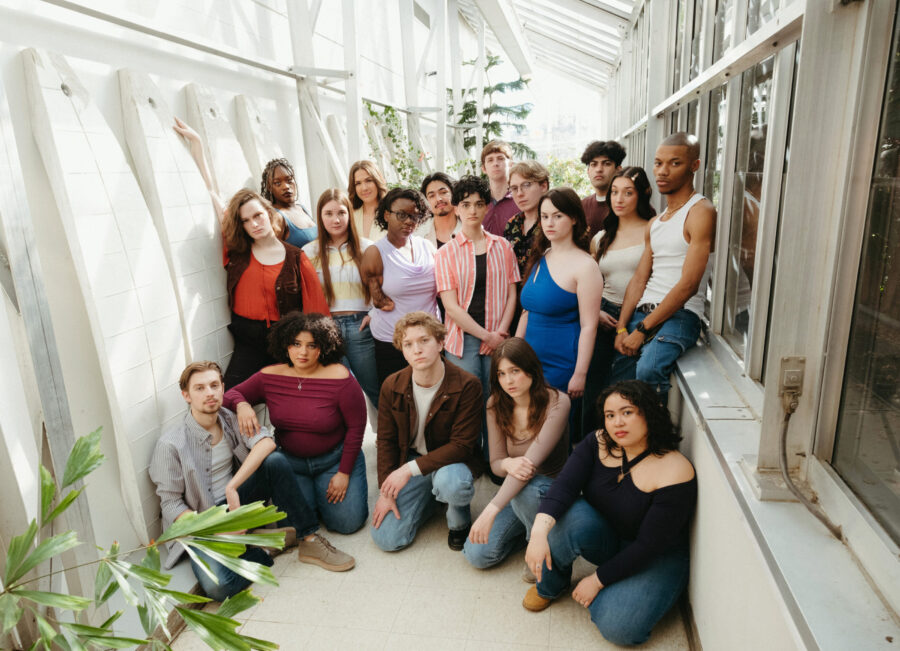 many people gathered on and around a table with serious looks