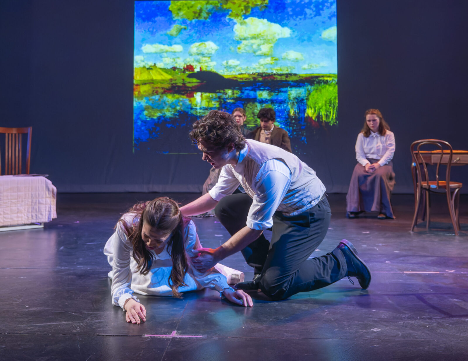 two people sitting on crates during a black box performance